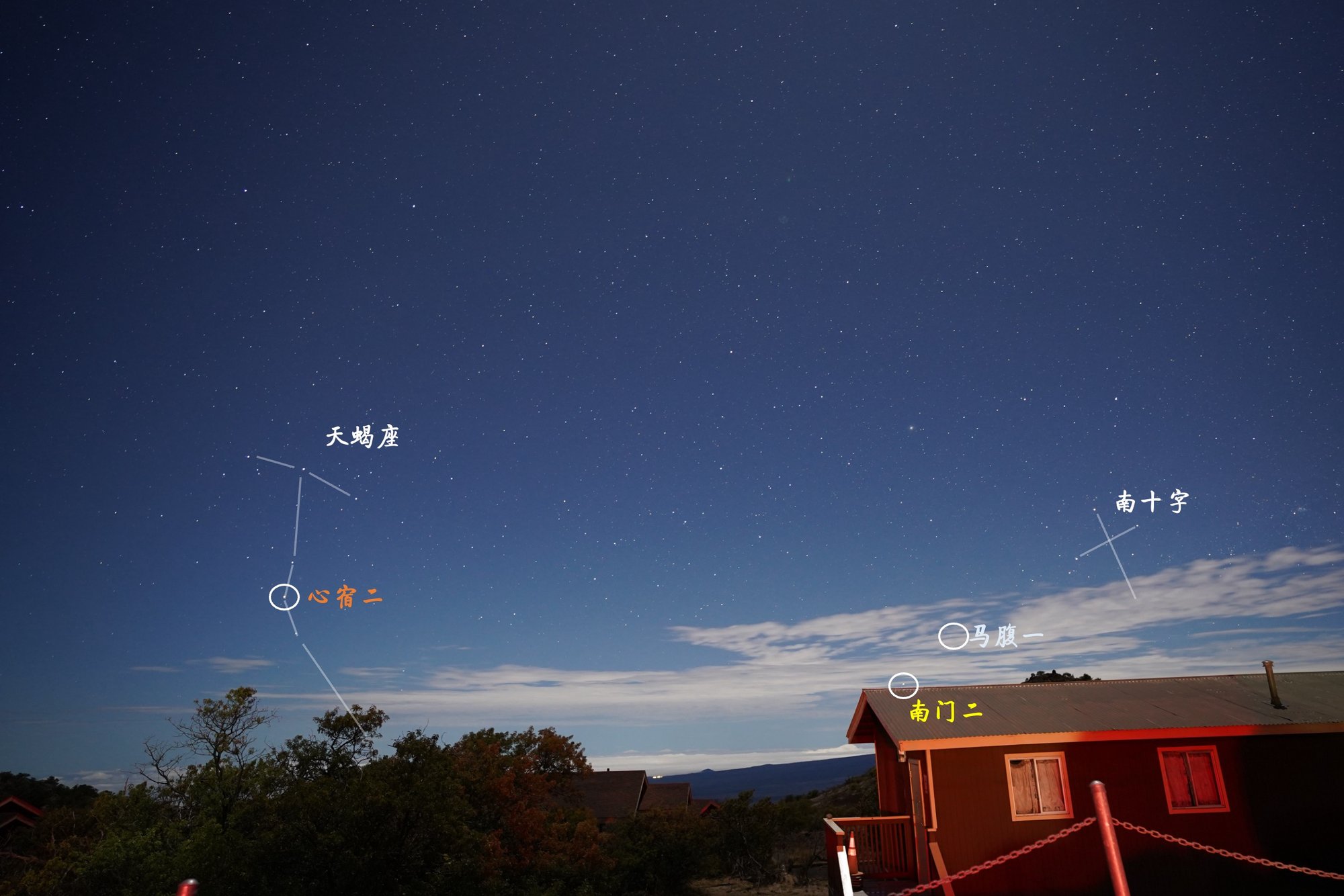 Night sky over a red cabin on Mauna Kea, Hawaii, with Alpha Centauri, Hadar, the Southern Cross, Antares and Scorpius labeled